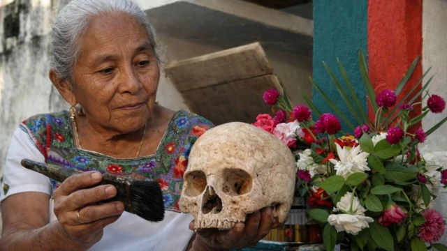 Une femme nettoyant des ossements, cimetière de Pomuch - Campeche